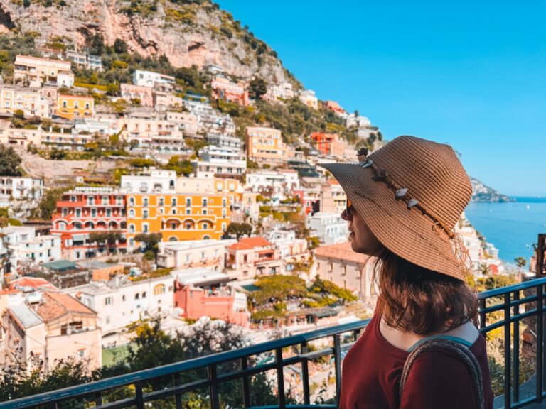 A woman standing on a balcony looking at the ocean