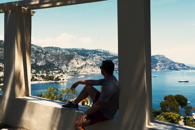 man in gray t-shirt sitting on window during daytime