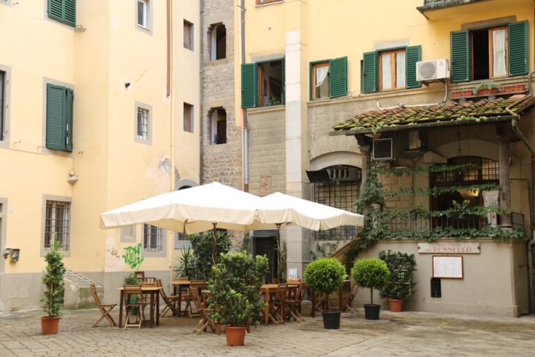 white patio umbrella near brown wooden chairs and white patio umbrella during daytime