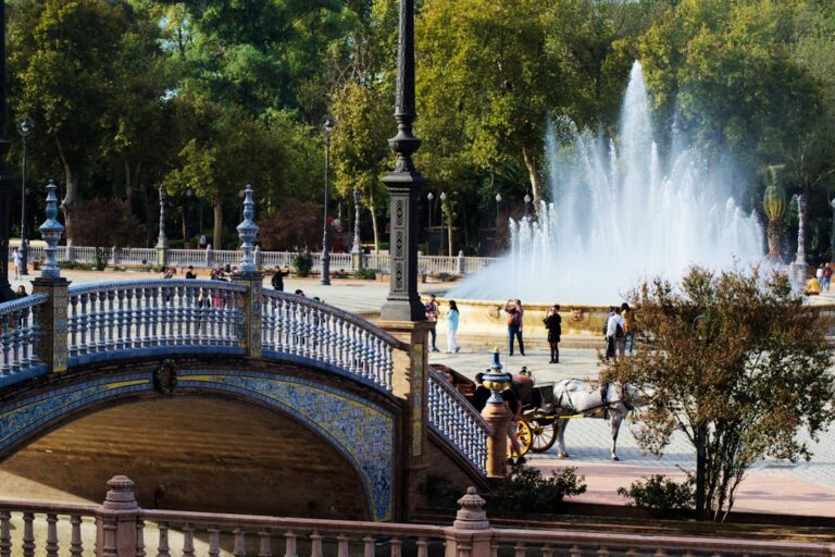 Bridge and fountain in a sunny park with people