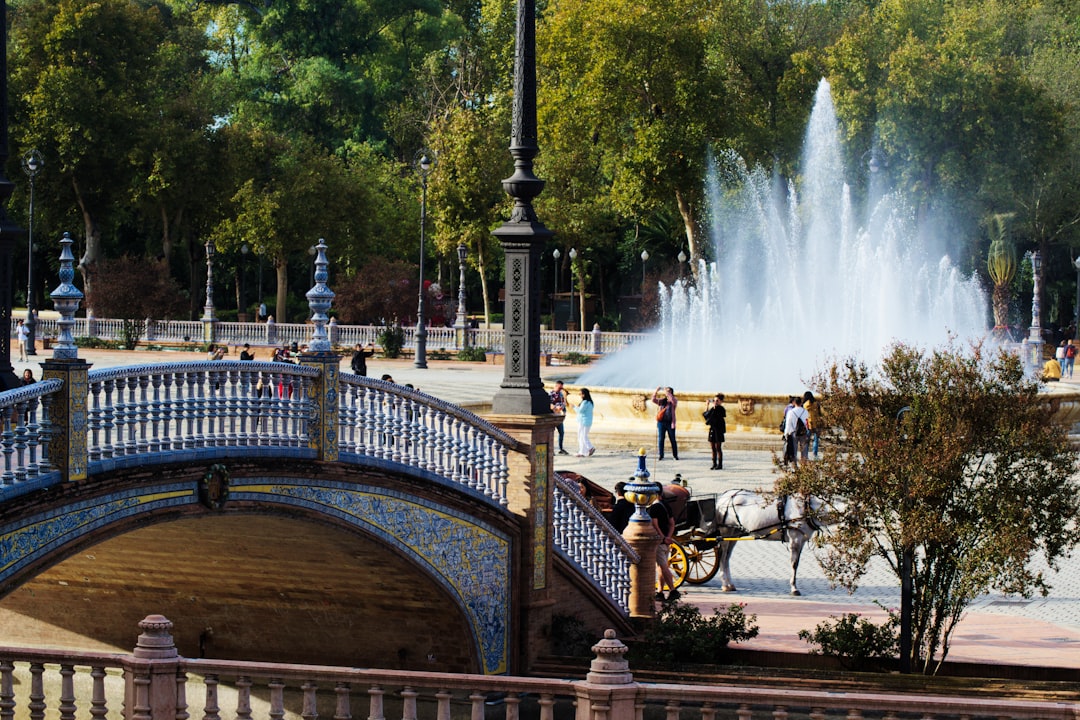 Bridge and fountain in a sunny park with people