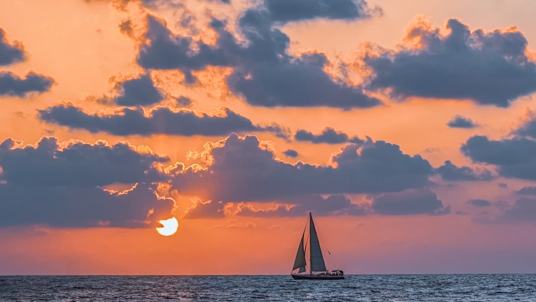 A sailboat in the ocean at sunset