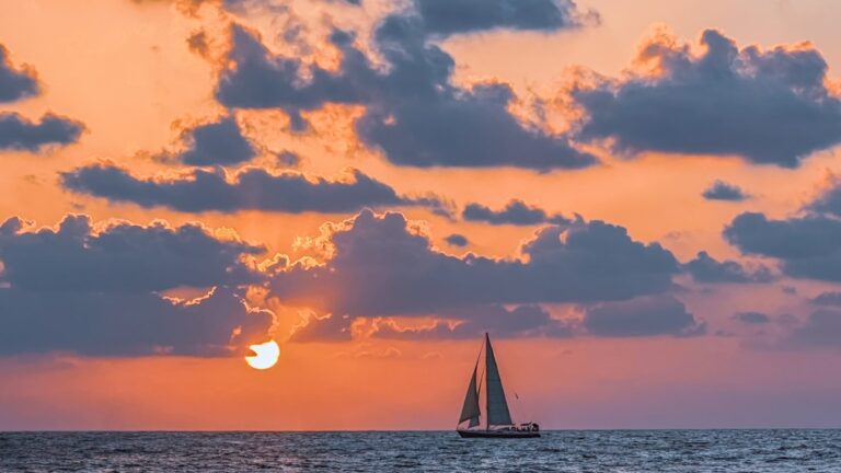 A sailboat in the ocean at sunset