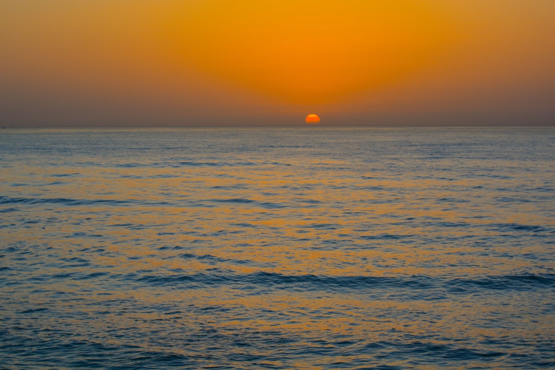 the sun is setting over the ocean