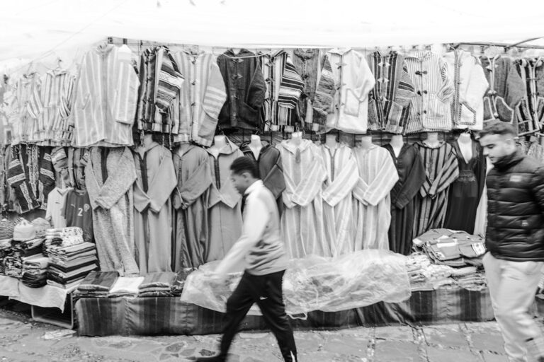 Traditional moroccan djellabas displayed at a market stall.