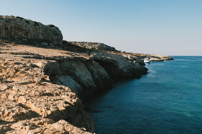 a body of water sitting next to a rocky cliff
