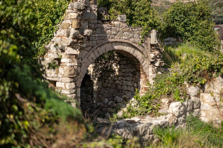 Ancient stone archway overgrown with green foliage